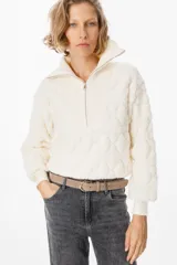 Sweater de tejido acolchado con diseño de rombos, color beige, con cuello polo y cierre frontal parcial. Presenta puños y cuello en tejido acanalado, con mangas largas y corte cropped.