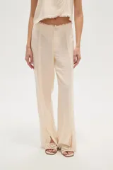 Pantalon de corte recto confeccionado en viscosa, color natural, con detalle de costuras desflecadas a lo largo de las piernas.