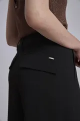Pantalón cargo negro de corte ancho, con bolsillos laterales con fuelle y trabillas en la cintura.