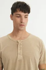 Remera gris de corte clásico, cuello redondo con botones y mangas cortas.
