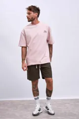 Remera de algodón color verde oliva, corte oversize, con cuello redondo y un pequeño logo bordado en el pecho.