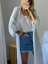 Minifalda de jean azul con botones frontales y ruedo desflecado.