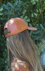 Gorra ajustable con visera color marrón de efecto cuero.