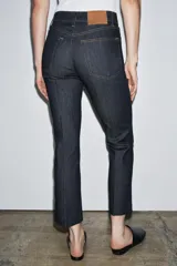 Jeans de mezclilla azul claro, tiro medio, corte recto y ligeramente acampanado en el bajo. Presenta cinco bolsillos y cierre frontal con cremallera y botón metálico.