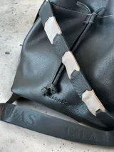 Bolso tipo marinero de cuero genuino negro, con cierre de cordón ajustable, correa corta de cuero y correa larga ajustable de tela.