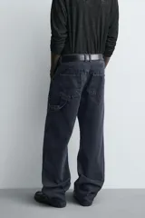 Jeans relaxed fit de corte holgado y amplio en toda la pierna, color negro con efecto lavado. Presenta tiro medio, bolsillos frontales, bolsillos traseros de plastrón y aplicación de tira multifunción en la pernera. Cierre frontal con cremallera y botón.