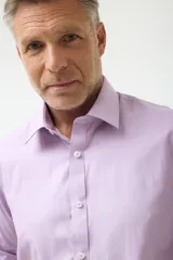 Camisa de vestir blanca de manga larga, con cuello clásico y cierre frontal de botones. Presenta un corte entallado que se adapta a la silueta.