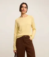 Suéter de punto color beige, con cuello redondo y mangas largas. Diseño básico y versátil de calce cómodo.