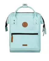 Mochila Cabaia modelo Adventurer en color turquesa claro. Cuenta con un compartimento principal con cierre, un bolsillo frontal con cierre y detalles en cuero sintético marrón, incluyendo parches con el logo de la marca. Posee asas superiores para llevar en la mano y correas ajustables para los hombros.