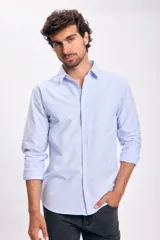 Camisa de vestir celeste con rayas verticales blancas, de corte clásico, manga larga con puños abotonados y bolsillo en el pecho.