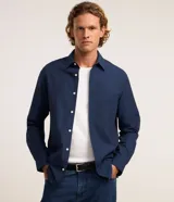 Camisa de corte regular, color azul marino, con cuello inglés, manga larga y cierre frontal abotonado. Confeccionada en tejido plano de mezcla de algodón y poliéster.