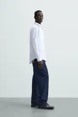 Camisa de algodón de manga larga, color celeste claro, con cuello italiano y cierre frontal de botonadura.