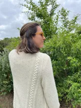 Cardigan tejido a mano color crudo, con solapa en el escote y punto delicado.