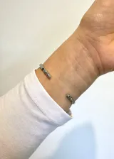 Pulsera rígida abierta de plata 925 con una zirconia violeta en el centro.