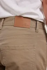 Pantalón de corte recto y estilo clásico, confeccionado en sarga de algodón con elastano. Cuenta con diseño de cinco bolsillos, cierre frontal con botón metálico y costuras reforzadas.