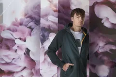 Campera verde oscuro con capucha, cierre frontal y bolsillos laterales.