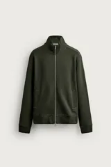 Chaqueta regular fit confeccionada en tejido técnico interlock de algodón con elasticidad. Presenta cuello subido, cierre frontal con cremallera, bolsillos de vivo en la cadera y acabados en rib en puños y bajo.