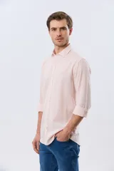 Camisa de manga larga confeccionada en mezcla de lino y algodón, con sutiles rayas celestes, cuello camisero clásico y cierre frontal de botones.