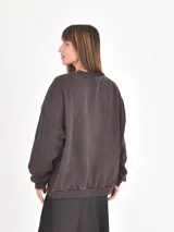 Buzo de cuello redondo y manga larga, con diseño holgado y efecto de lavado gastado.