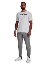 Pantalón de jogging Under Armour Rival Fleece para hombre, color gris melange, con cintura elástica ajustable, bolsillos laterales y logo bordado en la pierna izquierda. Corte ajustado en los tobillos.