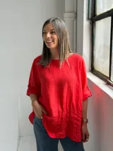 Blusa roja de lino, con cuello redondo, mangas 3/4 con presilla y botones, y diseño holgado con pliegues frontales.