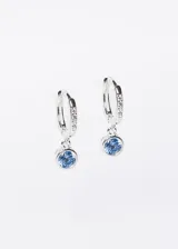 Par de aros plateados tipo argolla con circonitas incrustadas y dije colgante de circonita celeste.