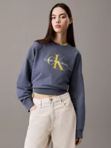 Buzo azul de felpa con cuello redondo y logo Calvin Klein Jeans estampado en amarillo en el pecho.