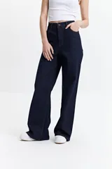 Pantalón de jean azul oscuro, de corte wide leg y tiro alto, con costuras a la vista y cierre frontal con botón.