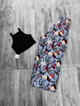 Pantalón palazzo estampado con flores rojas y amarillas sobre fondo celeste, con cintura elástica.