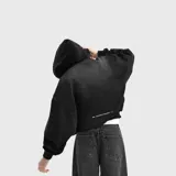 Hoodie negro de corte oversize con capucha y estampado minimalista en la parte inferior trasera. Confeccionado en algodón de alta calidad con textura suave.