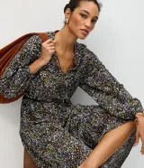 Vestido midi de viscosa con estampado de lunares multicolores sobre fondo oscuro, escote en V con cordones y mangas abullonadas.