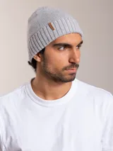 Gorro de lana gris con detalle de etiqueta de cuero con logo de la marca en el lateral.