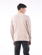 Campera tejida de punto con cierre frontal, cuello redondo y puños acanalados. Presenta una textura sutil en el tejido y un diseño versátil.