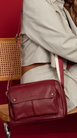 Bandolera de símil cuero color verde menta, con apertura central de cierre, bolsillo principal con cierre metálico y bolsillo frontal con tapa y broches magnéticos. Incluye bolsillos internos y posterior, y correa de galón combinada larga y regulable.