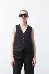 Chaleco sastrero color marrón oscuro, con escote en V, cierre frontal de botones y pinzas de entalle.