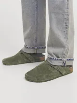 Zueco de gamuza verde militar con puntera redonda, tira ajustable con hebilla lateral, plantilla anatómica de corcho y suela de goma.