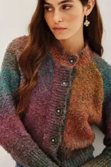 Cardigan de punto con diseño multicolor en tonos tierra y violeta, de corte cropped y manga larga. Presenta cierre frontal con botones oscuros y cuello redondo.