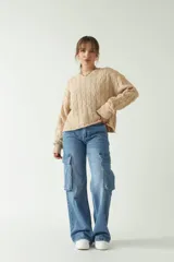 Sweater tejido color beige con trama de ochos y cuello redondo.