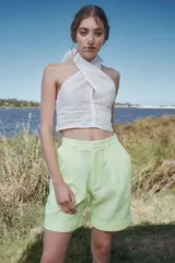 Bermuda de tiro alto color salmón con textura broderie, corte amplio, pinzas delanteras y ruedo con dobladillo.