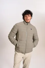 Campera puffer color beige con cierre frontal, cuello alto y logo de la marca bordado en el pecho.