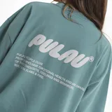 Remera de algodón con corte oversize, color verde azulado, con cuello redondo y estampado frontal en relieve con logo de la marca.