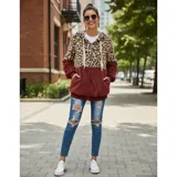 Campera tipo polar con cierre frontal, diseño combinado con estampado animal print en la parte superior y tejido de peluche blanco en la parte inferior. Cuenta con capucha con cordones ajustables y dos bolsillos frontales.
