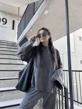 Buzo deportivo gris nevado con costuras externas y tela elastizada.