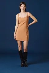 Vestido corto de color tostado, con escote cuadrado y tirantes anchos. Presenta un corte entallado con costuras verticales que definen la silueta.