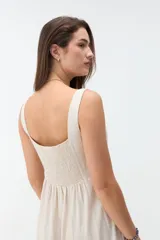 Vestido midi negro con escote cuadrado, tirantes anchos y falda de corte acampanado.