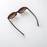 Lentes de sol con armazón ovalado de carey y cristales marrones degradados.