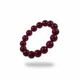 Pulsera elástica compuesta por cuentas esféricas de resina en color bordó translúcido.