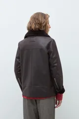 Chaqueta de eco cuero color chocolate con interior y cuello forrados en piel sintética al tono. Presenta cierre frontal completo, bolsillos laterales y diseño de corte recto.