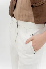 Pantalón de tiro medio y piernas anchas, confeccionado en mezcla de lino y algodón, con bolsillos delanteros y traseros con detalles de costuras pespunteadas a contratono.