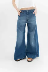 Pantalón de jean azul de pierna ancha y tiro medio, con cinco bolsillos y pespuntes a contratono.